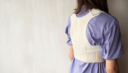 Orthopedic lumbar corset and back posture corrector. Posture corrector for the spine. Correction of scoliosis in a teenage girl. - obrazy, fototapety, plakaty