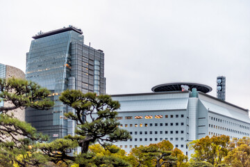 Osaka, Japan modern buildings cityscape closeup and trees looking up on roof and helicopter landing...