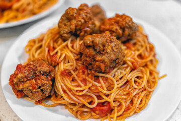 Red tomato sauce spaghetti pasta noodles closeup with ground beef meatballs on plate in marinara sauce