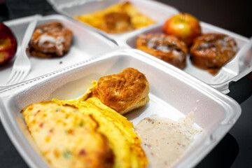 Fresh hot buffet styrofoam tray with breakfast food eggs omelette from free morning continental...