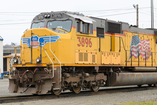 Seattle - March 20, 2022; Union Pacific locomotive in yellow with logo and US flag at Seattle Argo Yard, a UP intermodal freight facility