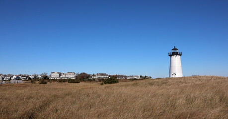Edgartown lighthouse with a view of the city in the background and blue sky