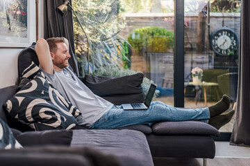 Calm caucasian man, watching a series, relaxing at home.