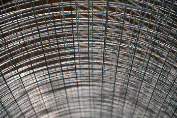 Construction grid with a square cell rolled into a roll. Close-up selective focus. A roll of mesh wire made of steel.
