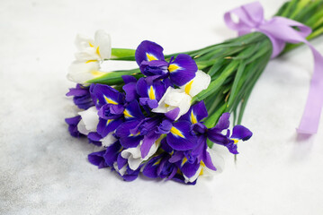 bouquet of lilac and white irises on a grey background. Horizontal view.