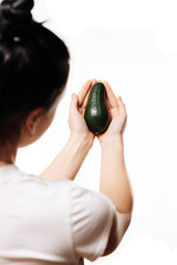 avocado in a female hand on a white background