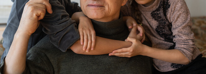 Ukrainian grandfather and two granddaughters hugging