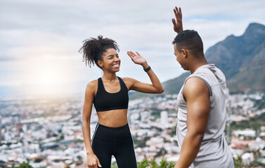 Theyre pumped with so much energy. Shot of a sporty young couple high fiving each other while exercising outdoors.