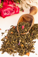 Fototapeta premium Heap of Dry green tea, white tea leaves with herbs in a wooden spoon on white background.