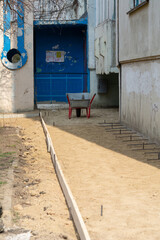 Foundation blind area preparing. Basic formwork marking. Blind area construction near the house. Hammer iron armature at the base of the house