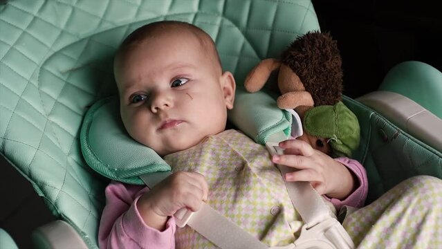 beautiful, happy, cute, surprised, excited little baby looks camera, with blue eyes, child's chair kitchen, children's clothes. He smiles, amuses himself, shakes his legs, arms, drools. Dimples cheeks