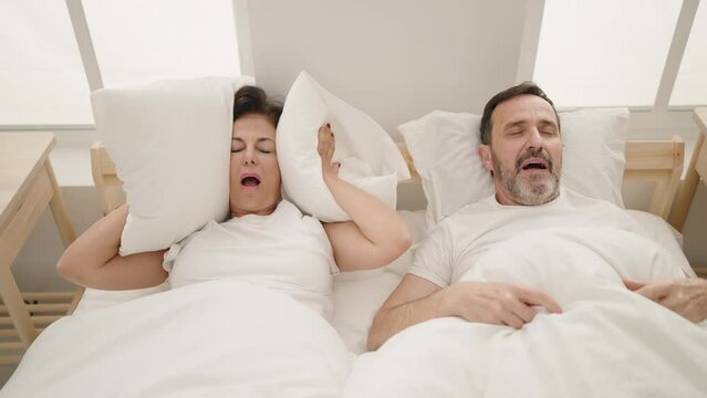 Man and woman couple sleeping on bed snoring at bedroom