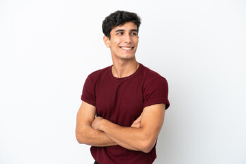 Young Argentinian man isolated on white background looking to the side and smiling