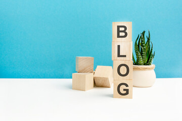 blog - word is written on wooden cubes on a blue background. close-up of wooden elements. in the...