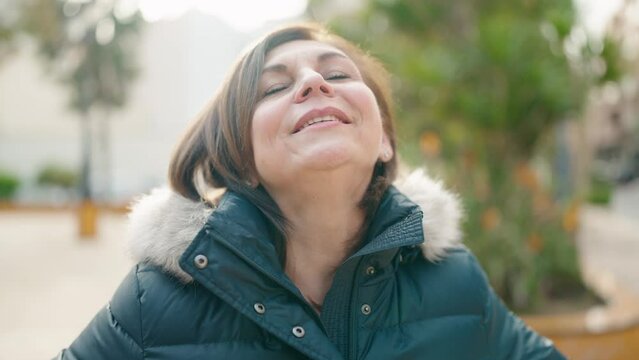 Middle age woman smiling confident breathing at park