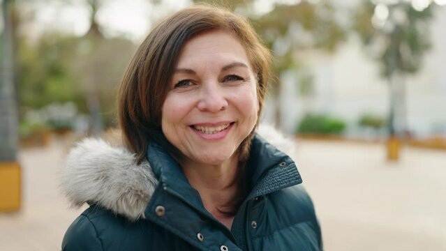 Middle age woman smiling confident standing at park
