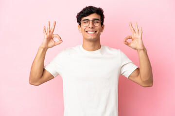 Fototapeta premium Young Argentinian man isolated on pink background in zen pose