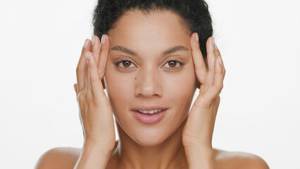 Big close-up beauty portrait of young African American woman lifts skin around her eyes with...