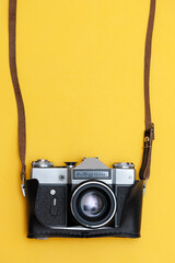 Camera on yellow background, vertical photo