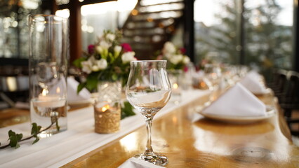 Empty Glass on Engagement Table Decorated with Flowers and Candles