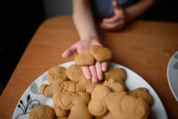 Gingerbread in the form of a heart in the hand of a child, gingerbread man, mouse