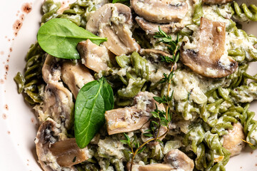 Close up Mushroom and Spinach Pasta in a Bowl, Vegan Food on light background. Vegan or gluten free diet, top view