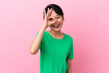 Young Vietnamese woman isolated on pink background showing ok sign with fingers