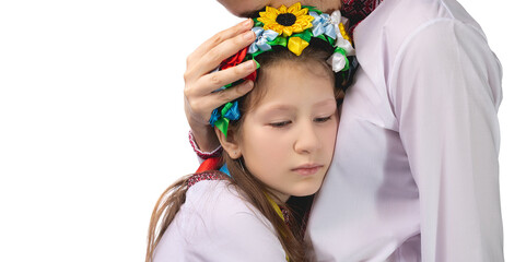 The mother hugs the child with tearful eyes. A child in Ukrainian national clothes.