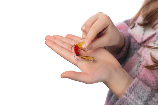 The child holds in his hands an orthodontic appliance and a key to adjust it. The concept of teeth alignment in childhood. Studio photo on a white background.
