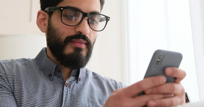 Thoughtful man using mobile phone at home