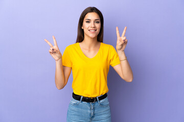 Young caucasian woman over isolated background showing victory sign with both hands