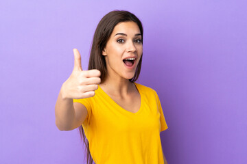 Young caucasian woman over isolated background with thumbs up because something good has happened