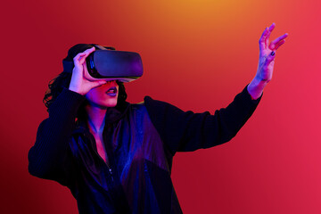 The young woman is using virtual reality viewer. Modern woman portrait with trendy look and bright colors.