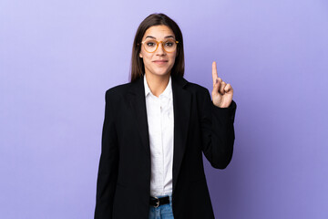 Business woman isolated on purple background pointing with the index finger a great idea