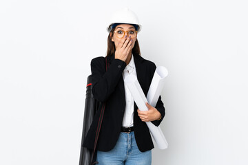 Young architect caucasian woman with helmet and holding blueprints over isolated background with surprise facial expression