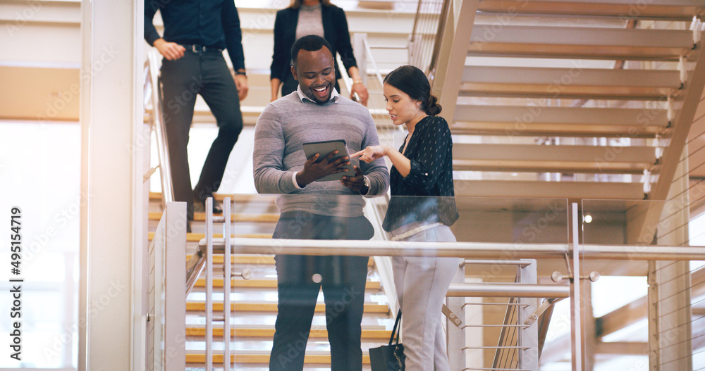 Poster theyve found the right app to work with. cropped shot of two young businesspeople using a digital ta