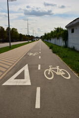 Asphalt road for cyclists stretching far into the future with appropriate signs applied on it