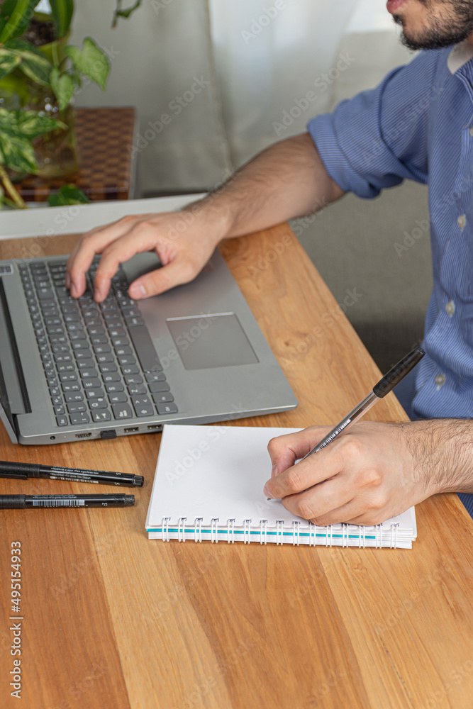 Fototapete office worker writes and annotates while working in his office.