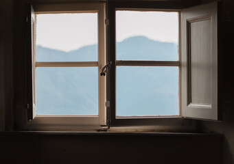 View at the mountains through an old fashioned window, remote getaway & staycation concept