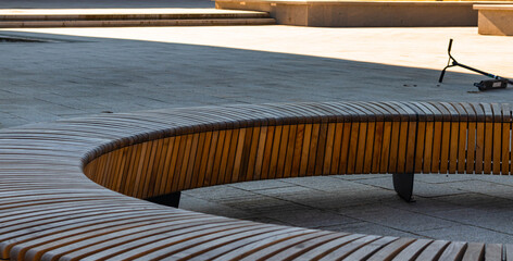 Close-up photo of a round wooden bench showing the color and arrangement of the wood and also the...