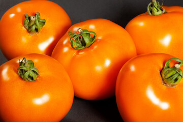 orange tomato on black background