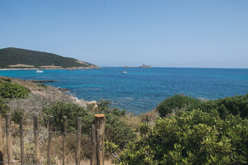Corsican scrubland overhanging the coasts and beaches of Corsica near the Mediterranean Sea where several boats have dropped anchor