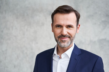 Close-up portrait of mid adult businessman smiling and looking at camera