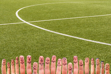 Fingermännchen als Fußballmannschaft vor einem Fußballfeld als Hintergrund für individuelle...