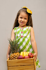 niños felices niña niño cargando canasta de rica fruta piña plátano banana manzana posando y disfrutando - obrazy, fototapety, plakaty