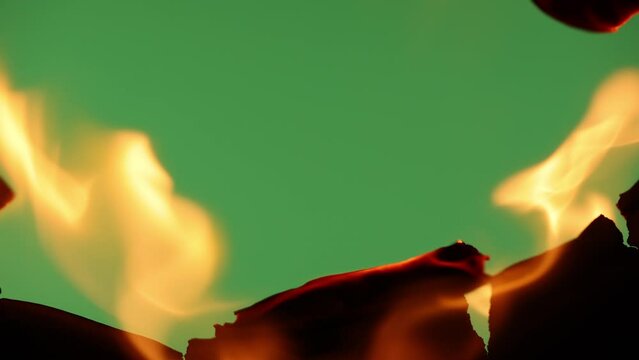 Transition. Black paper is on fire on a green background.