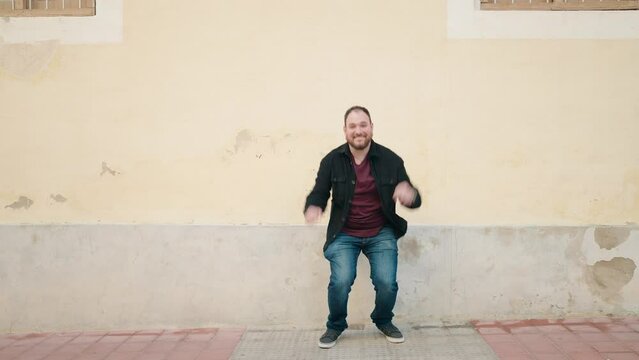 Young plus size man smiling confident jumping at street