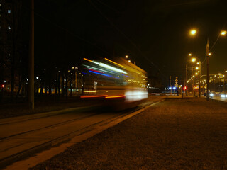 Fototapeta na wymiar tram in motion at night passing by, light trails