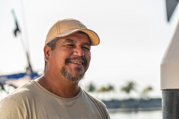 Portrait of a mature latin fisherman smiling at the dock