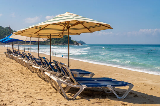 Sunbeds and umbrellas at the beach on a sunny summer morning